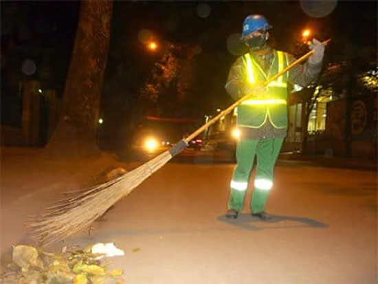 Chị lao công sử dụng áo phản quang trong đêm giúp người khác dễ nhìn thấy